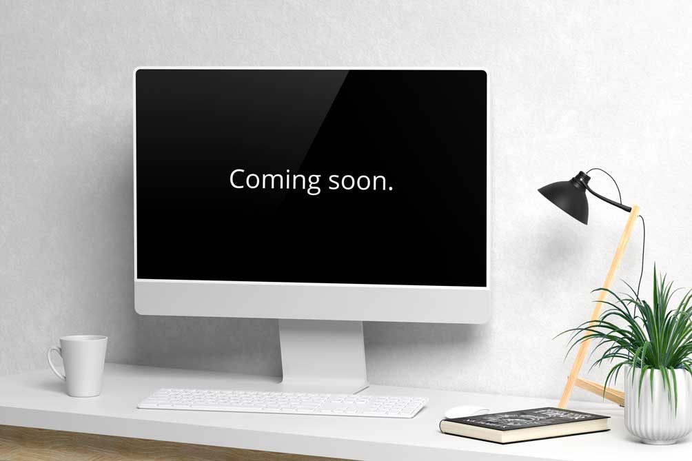 A Mac on a desk showing "coming soon"